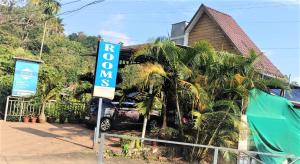 a sign in front of a house with a car at Riya Home Stay Munnar in Anaviratty