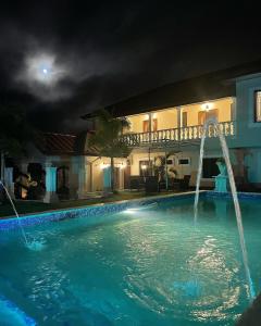 een zwembad 's nachts met een huis bij Vintage Oaks Hideaway 
