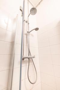 a shower with a shower head in a bathroom at 2ndhomes Mikonkatu Apartment 4 in Helsinki