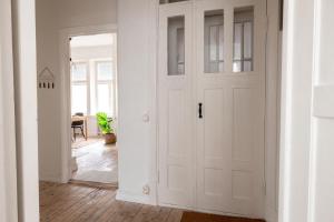 a hallway with a white door and a table at 2ndhomes Mikonkatu Apartment 4 in Helsinki