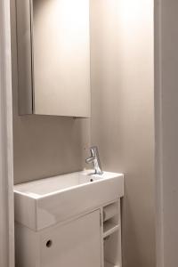 a bathroom with a white sink and a mirror at 2ndhomes Mikonkatu Apartment 4 in Helsinki