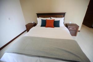 a bedroom with a large bed with two night stands at Hidden relaxation at Kings residence in Kandy