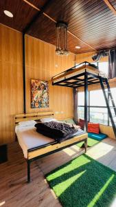 a bedroom with a bunk bed in a room at Into The Wild Stays in Dhanaulti