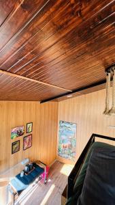a room with a bed and a wooden ceiling at Into The Wild Stays in Dhanaulti