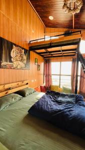 a bedroom with a large bed in a room at Into The Wild Stays in Dhanaulti