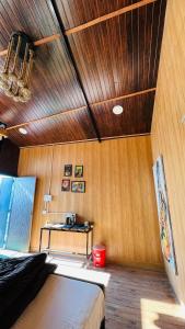 a bedroom with a bed and a wooden ceiling at Into The Wild Stays in Dhanaulti