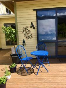 two blue chairs and a table on a porch at Off the Beaten Track B&B in Canvastown