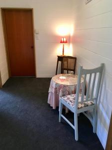 a room with a table and a chair and a lamp at Off the Beaten Track B&B in Canvastown