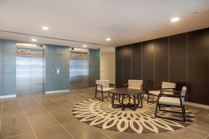 a meeting room with a table and chairs on a rug at Bayside Melbourne Apartment in Melbourne