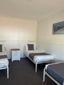 a room with two beds in a hotel room at Busselton Jetty Chalets in Busselton