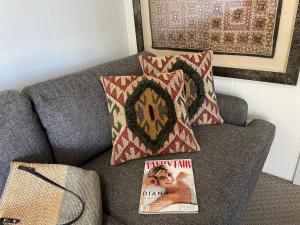 a book sitting on top of a couch with a pillow at Sisters Beach House in Sisters Beach +23 photos