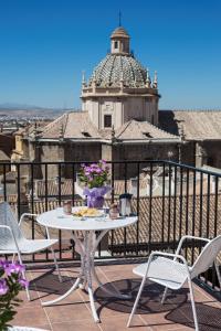 una mesa y sillas en un balcón con una torre en Hotel Molinos, en Granada