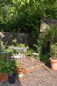 a patio with a table and chairs in a garden at gite d'Albertine in Ully-Saint-Georges