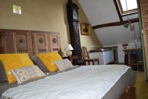 une chambre avec un grand lit avec des oreillers jaunes dans l'établissement gite d'Albertine, à Ully-Saint-Georges