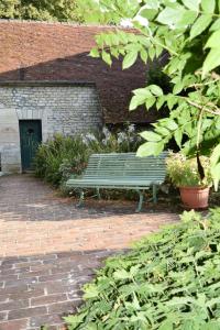 un banc vert assis devant un bâtiment dans l'établissement gite d'Albertine, à Ully-Saint-Georges 8 autres photos