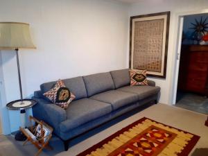 a living room with a blue couch and a lamp at Sisters Beach House in Sisters Beach