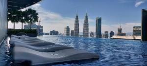 a infinity pool with a view of a city at Eaton KLCC Suites By Elite in Kuala Lumpur