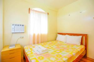 1 dormitorio con cama y ventana en Necy's Homestay, en Basco