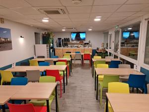 a dining room with tables and colorful chairs at Ibis Budget Boulogne-Sur-Mer Centre les Ports in Boulogne-sur-Mer