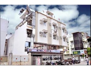 un edificio blanco alto en una calle de la ciudad en Hotel Pearl,Indore en Indore