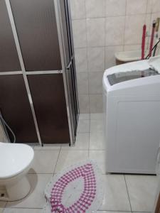 y baño con ducha, aseo y alfombra. en Loft Bela Vista, en São Paulo
