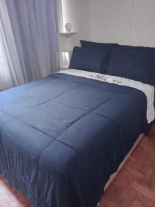 Una cama azul con una manta azul encima. en Loft Bela Vista, en São Paulo