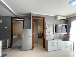 ein Wohnzimmer mit einem Kühlschrank und einer Küche in der Unterkunft 2BR Gateway Pasteur Apartment in Bandung