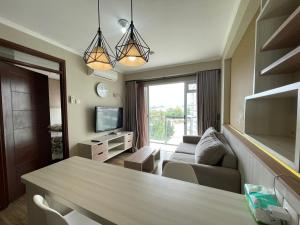 ein Wohnzimmer mit einem Tisch und einem Sofa in der Unterkunft 2BR Gateway Pasteur Apartment in Bandung