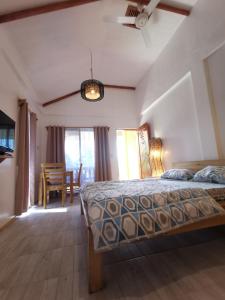 Un dormitorio con una cama y un comedor. en Saschas Place, en Siquijor