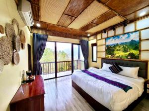 um quarto com uma cama grande e uma janela grande em DONG VAN CLIFFSIDE HOUSE em Dồng Văn