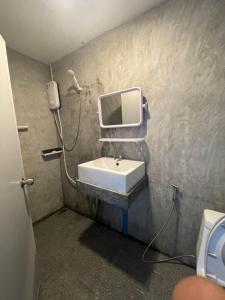 uma casa de banho com um lavatório e uma televisão na parede em Escape Divers Hostel em Ko Tao