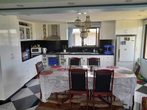 a kitchen with a table and chairs and a kitchen with white cabinets at Karans Apartment in Varoka