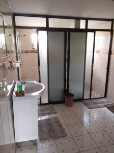 ein Bad mit einem Waschbecken und einer Dusche in der Unterkunft Karans Apartment 