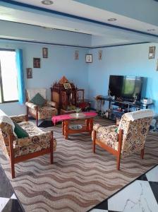 ein Wohnzimmer mit Sofas und einem Flachbild-TV in der Unterkunft Karans Apartment 