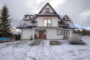 a house with snow on the ground in front of it at Wiyrchowianka in Gliczarów Górny