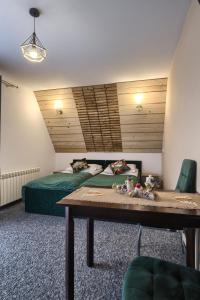 a room with two beds and a table in it at Wiyrchowianka in Gliczarów Górny