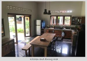 uma cozinha e área de refeições com uma mesa de madeira em Melati House Batukaras em Batukaras