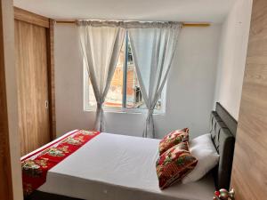 una camera da letto con un letto e una finestra di Travelu Guatape Apartamento a Guatapé