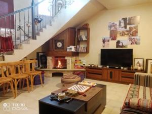 a living room with a tv and a staircase at Nonna Aisha B&B in Wadi Musa