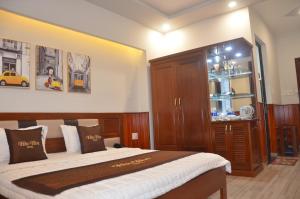 a bedroom with a bed and a wooden cabinet at Hào Hoa Hotel Kon Tum in Kon Tum