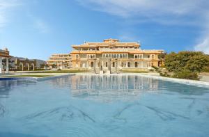 a large building with a swimming pool in front of it at Fateh Vilas by Fateh Collection in Udaipur