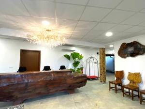 - un hall avec une grande table et des chaises en bois dans l'établissement Hôtel Belle Terre Resort, à Macouria