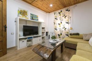 - un salon avec un canapé et une télévision dans l'établissement Casa Del Olivo, à Algésiras