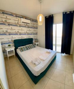 1 dormitorio con cama y pared de ladrillo en Mythical Sands Resort - Antonios, en Paralimni