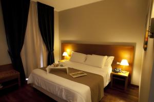 a hotel room with a large bed with two lamps at Hotel Tiziano in Trapani