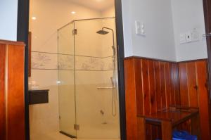 y baño con ducha y puerta de cristal. en Hào Hoa Hotel Kon Tum, en Kon Tum