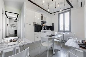 eine weiße Küche mit weißen Tischen und Stühlen in der Unterkunft The Upper Suites in Rom
