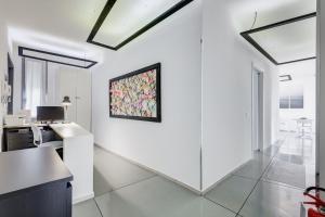 una sala de estar blanca con una pintura en la pared en The Upper Suites, en Roma