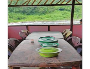 una mesa de madera con cuatro tazones verdes. en Rishi River Cottage, West Bengal en Pedong