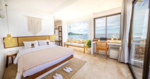 um quarto com uma cama, uma secretária e uma janela em The AVA Resort Koh Tao em Ko Tao